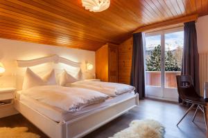 a bedroom with a bed and a large window at Hotel THE LARIX ski-in ski-out in Saas-Fee