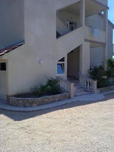 a house with a staircase leading up to it at Apartmani Marina in Rab