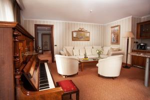 sala de estar con sofá y piano en Hotel Otrada, en Odessa