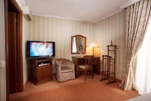 a living room filled with furniture and a tv at Hotel Otrada in Odesa