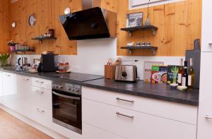 a kitchen with white cabinets and a black counter top at relactive-mosel Feriendomizil in Traben-Trarbach
