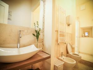 a bathroom with a white sink and a toilet at La finestra sul Teatro in Cortona +21 photos