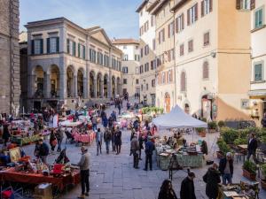 a group of people walking around a market in a street at La finestra sul Teatro in Cortona