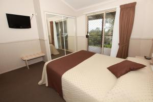 ein Hotelzimmer mit einem Bett und einem Fenster in der Unterkunft Lakesea Park in Durras