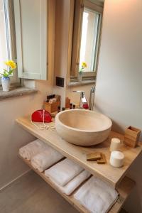 a bathroom with a large bowl sink on a wooden shelf at Borgese Camere e Suites in Neive
