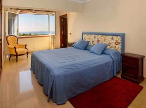 プエルト・カレロにあるCasa Juanitaのベッドルーム1室(青いベッド1台、椅子、窓付)