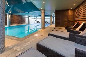 a large swimming pool with chairs and a table at Ginabelle 14 apartment - Chamonix All Year in Chamonix-Mont-Blanc