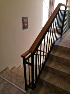 a staircase with a wooden rail and a picture on the wall at Mátyás Szállás in Szombathely