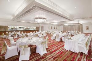 a banquet hall with white tables and chairs and a chandelier at Leonardo Hotel - Formerly Jurys Inn and Conference Venue Aberdeen Airport in Dyce