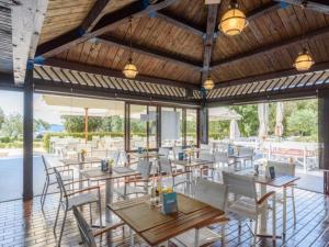 a restaurant with tables and chairs and windows at Easyatent Safari tent Polari in Rovinj