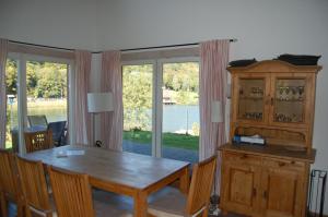 a dining room with a table and a large window at Traumhaus am See in Rieden +20 photos