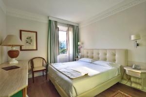 sypialnia z dużym łóżkiem i oknem w obiekcie Lolli Palace Hotel w San Remo