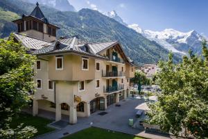 a large building with mountains in the background at Ginabelle 14 apartment - Chamonix All Year in Chamonix-Mont-Blanc
