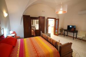 ルッファーノにあるCorte di Pietraのベッドルーム1室(カラフルな毛布付きのベッド1台付)