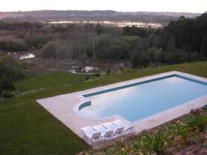 an aerial view of a large swimming pool with chairs at Quinta do Louredo Hotel in Espinhel