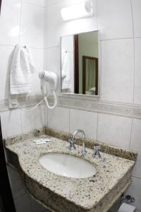 a bathroom with a sink and a mirror at Hotel Veneza in Brusque