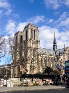 um grande edifício com uma igreja com uma torre em Hotel Esmeralda em Paris