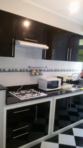 a kitchen with black and white cabinets and a stove at Addoha Apartment in Tangier