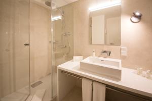 a bathroom with a shower, sink, and mirror at VI VADI HOTEL downtown munich in Munich