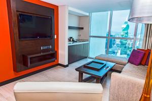a living room with a tv and a couch and a table at Megapolis Hotel Panama in Panama City