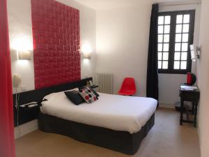 a bedroom with a bed and a red wall at Hôtel De La Loge in Perpignan +49 photos