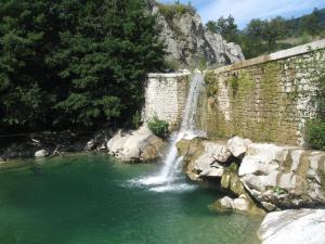 a waterfall next to a stone wall in a river at Agriturismo Il Casalone in Badia Tedalda