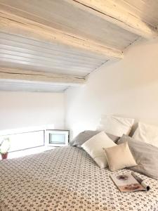 1 dormitorio con 1 cama con almohadas y TV en Mansarda al mare, en Rímini