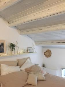 Schlafzimmer mit weißen Wänden und einem Bett mit Kissen in der Unterkunft Mansarda al mare in Rimini