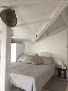 a bed in a white bedroom with a white ceiling at Mansarda al mare in Rimini