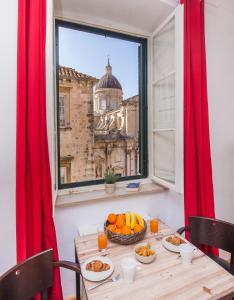 una mesa con un bol de fruta y una ventana en Arty Old Town Apartments by Irundo, en Dubrovnik