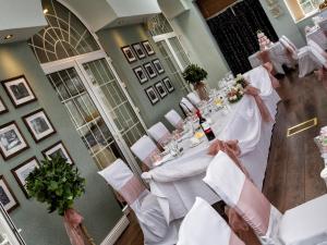 uma vista sobre uma sala de jantar com mesas e cadeiras brancas em Stradey Park Hotel em Llanelli