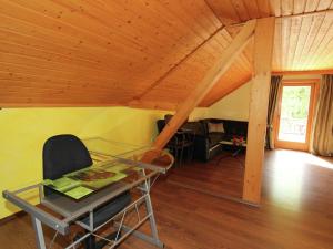 StallにあるHaus Waldschmied Exclusivの木製の天井の客室で、ガラスのテーブルと椅子が備わります。