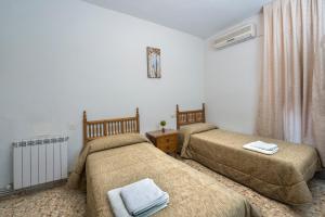 トレドにあるホスタル サンタ バーバラのベッドルーム1室(ベッド2台、ラジエーター付)