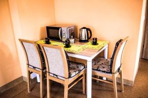 a table with a microwave and a table with two chairs at dom Bartków kielce in Zagnańsk