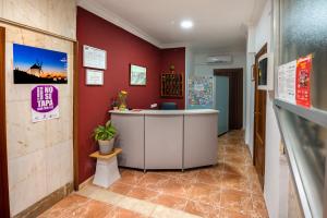 ein Büro mit einer Theke und roten Wänden in der Unterkunft Hostal Santa Barbara in Toledo