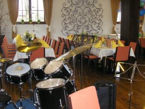 Zimmer mit einem Tisch mit Trommeln auf dem Boden in der Unterkunft Hotel-Pension Schwaighofen in Eugendorf