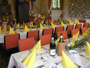un grupo de mesas con servilletas amarillas y botellas de vino en Hotel-Pension Schwaighofen, en Eugendorf