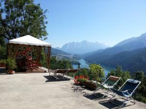 two chairs and a gazebo with a view of a lake at Dolomiti in Pieve di Cadore