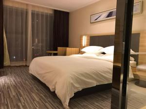 Rúm í herbergi á Hotel Pomelo Premier 西柚臻选武昌站酒店
