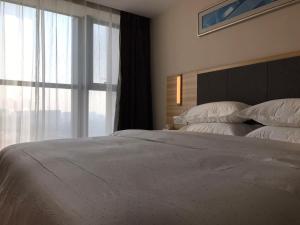 Rúm í herbergi á Hotel Pomelo Premier 西柚臻选武昌站酒店