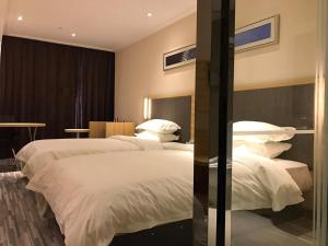 Rúm í herbergi á Hotel Pomelo Premier 西柚臻选武昌站酒店