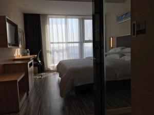 Rúm í herbergi á Hotel Pomelo Premier 西柚臻选武昌站酒店