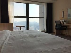 Rúm í herbergi á Hotel Pomelo Premier 西柚臻选武昌站酒店