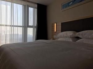Rúm í herbergi á Hotel Pomelo Premier 西柚臻选武昌站酒店