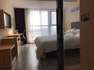 Rúm í herbergi á Hotel Pomelo Premier 西柚臻选武昌站酒店