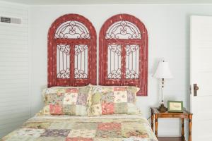 sypialnia z dużym drewnianym zagłówkiem i dwoma oknami w obiekcie The Little Farmhouse Sleeps 6 w mieście Columbia