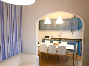 ナザレにあるCasa do Cabetaのキッチン(青いキャビネット、白いテーブルと椅子付)