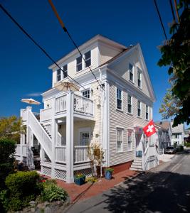 a white house with a flag in front of it at Benchmark Inn in Provincetown