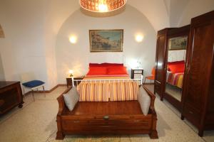 1 dormitorio con 1 cama con almohadas rojas en Corte di Pietra, en Ruffano