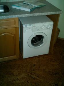 a washing machine in a kitchen next to a counter at Spezialitätenhof Familie Eichmann in Neuhaus am Klausenbach